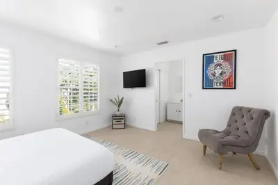 a bedroom with a bed and a chair and a television at 3 bedroom near Culver City-Palms in Los Angeles