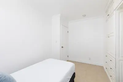 a white bedroom with a bed and white cabinets at 3 bedroom near Culver City-Palms in Los Angeles