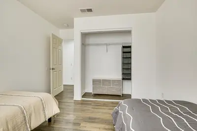 a white bedroom with a bed and a closet at Pool Table and Charcoal Grill Home in Victorville! in Victorville
