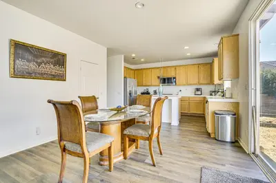 a kitchen and dining room with a table and chairs at Pool Table and Charcoal Grill Home in Victorville! in Victorville