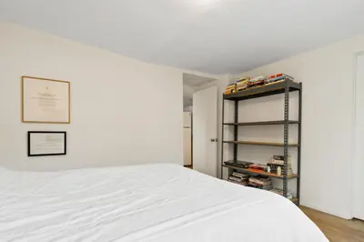 a bedroom with a white bed and a shelf at Peaceful Tranquility w Nature in Los Angeles