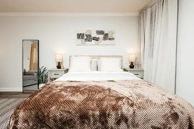a bedroom with a large bed and two tables at Oceanfront Studio with balcony in Redondo Beach
