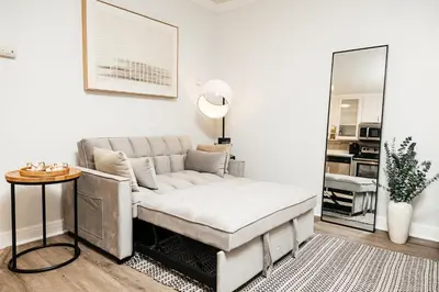 a living room with a couch and a mirror at Oceanfront Studio with balcony in Redondo Beach