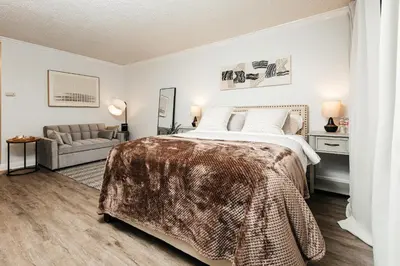 a bedroom with a large bed and a couch at Oceanfront Studio with balcony in Redondo Beach