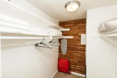a closet with white shelves and a red suitcase at Oceanfront Studio with balcony in Redondo Beach