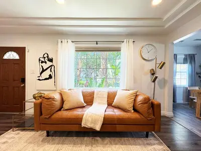 a brown couch in a living room with a window at Charming 2BR Spot Near LAX, SoFi and Forum - MK1-LAD in Los Angeles