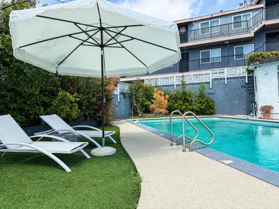 a pool with chairs and an umbrella next to a pool at Perfect 1-BR Spot Near LAX, SoFi and Forum - MK2-LAD in Los Angeles