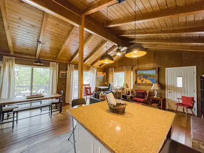 a kitchen and living room with wooden ceilings and a table at Casita de Sergio - Peek-A-Boo Lake View, Walk to Lake, Fireplace in Big Bear Lake