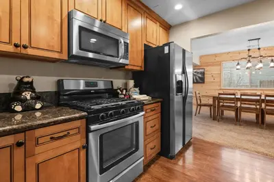 a kitchen with a stove and a microwave at Eagle Point Retreat - Sleeps 13 - 12 Adults Max, Game Room, Foosball, Fireplace, Deck, Barbecue in Big Bear Lake