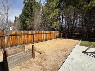 a backyard with a wooden fence at Eagle Point Retreat - Sleeps 13 - 12 Adults Max, Game Room, Foosball, Fireplace, Deck, Barbecue in Big Bear Lake