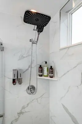 a shower in a bathroom with white marble walls at Luxury 2BR Stay Balcony Views and Free Parking in Los Angeles