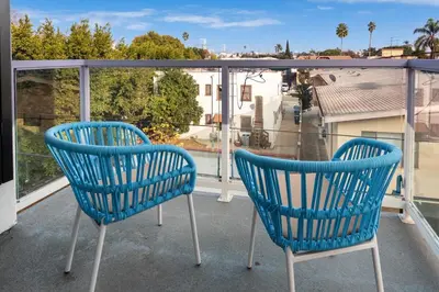 two blue chairs on a balcony with a view at Modern and Chic 2BR Gem with Luxe Finishes, Parking in Los Angeles