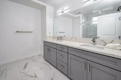 a white bathroom with a sink and a mirror at Experience Lavish LA Living Sleek 2BR with Parking in Los Angeles