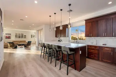 a kitchen with wooden cabinets and a island with bar stools at Ultimate Luxurious Penthouse with Private Balcony in Los Angeles