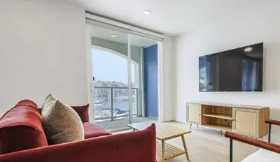 a living room with a red couch and a television at Modern Marina Escape with Harbor Views in Los Angeles