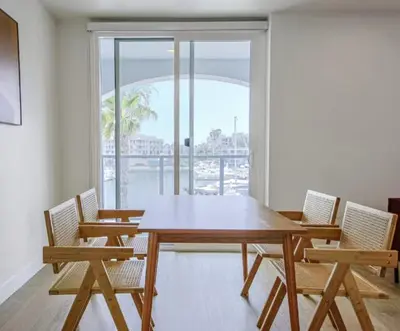 a wooden table and chairs in a room with a window at Modern Marina Escape with Harbor Views in Los Angeles