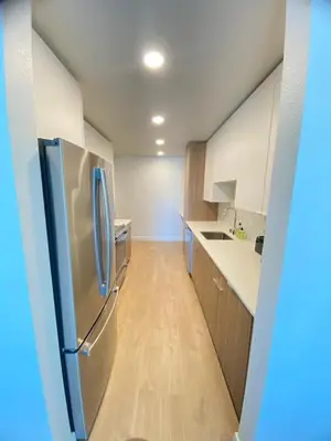 a kitchen with a refrigerator and a wooden floor at Modern Marina Escape with Harbor Views in Los Angeles