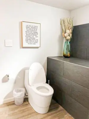 a bathroom with a toilet and a vase of flowers at Cozy LA Studio Steps from SoFi and LAX - SH3 - LAD in Los Angeles