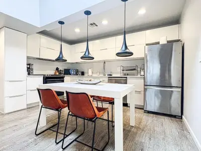 a kitchen with a white table and four chairs at Bright 2-BR Home Near LAX with Shared Yard - SH2-LAD in Los Angeles
