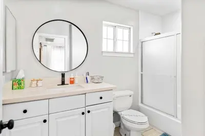 a white bathroom with a toilet and a mirror at Game Room & In-Unit Laundry - 15 Min to Disney! in Artesia