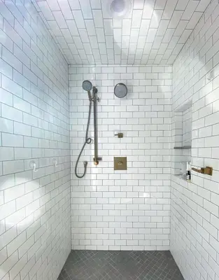 a bathroom with white tile walls and a shower at Channel Islands Beach Retreat in Oxnard