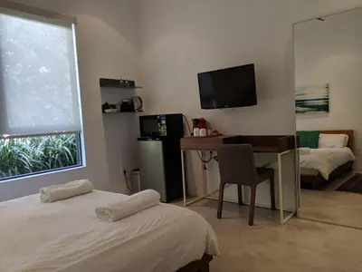 a room with two beds and a desk and a television at Luxury suite with private entrance in Los Angeles