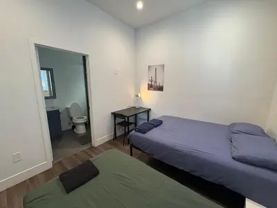 a bedroom with two beds and a bathroom with a toilet at Blue Stay Walk to BMO Stadium and USC in Los Angeles