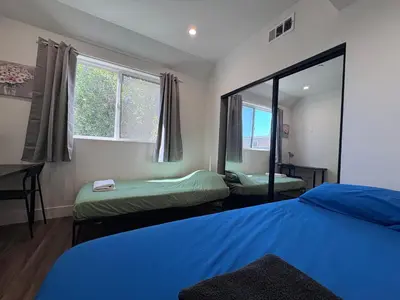 a room with two beds and a mirror at Blue Stay Walk to BMO Stadium and USC in Los Angeles