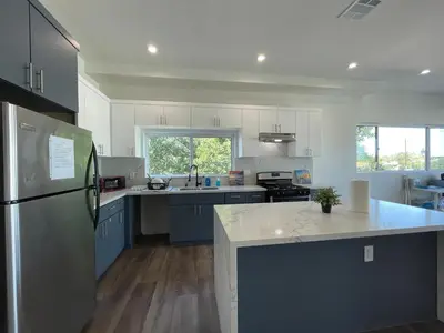 a kitchen with blue and white cabinets and a refrigerator at Blue Stay Walk to BMO Stadium and USC in Los Angeles