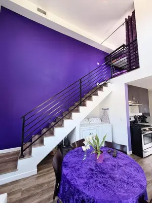 a dining room with a purple table and stairs at 3 bedroom with Hot Tub and Video game console 10 minutes from Rodeo Drive Beverly Hills in Los Angeles