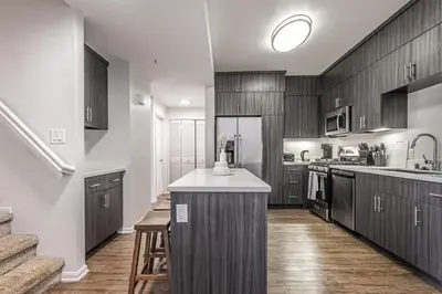 a kitchen with wooden cabinets and a kitchen island at Modern Townhouse with 4 Bedrooms Near LAX in Los Angeles
