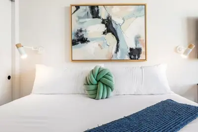 a bed with a green pillow on top of it at The Downtown Haven Suite, 1Mile to Dodger Stadium in Los Angeles