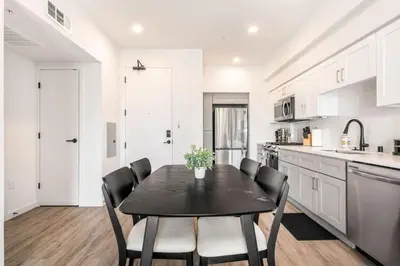 a kitchen with a black table and black chairs at The Sky loft Suite, DTLA Sunset Views in Los Angeles