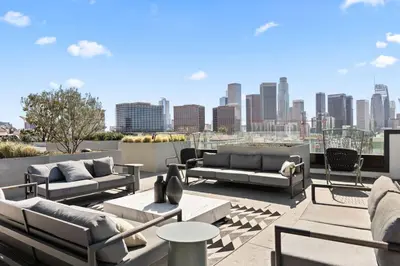 a rooftop patio with couches and a city skyline at The Sky loft Suite, DTLA Sunset Views in Los Angeles