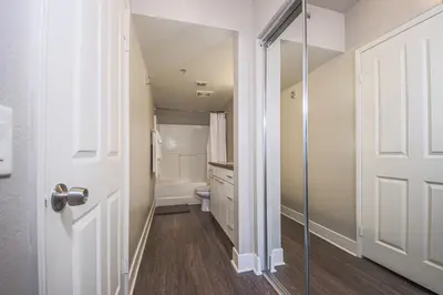 a small bathroom with a toilet and a door at Sunny 2BDR in SM Pool & Gym - 5 min to the beach! in Los Angeles