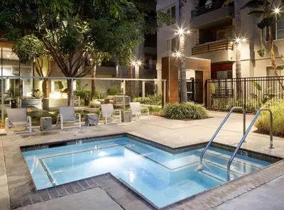a swimming pool in front of a building at Sunny 2BDR in SM Pool & Gym - 5 min to the beach! in Los Angeles