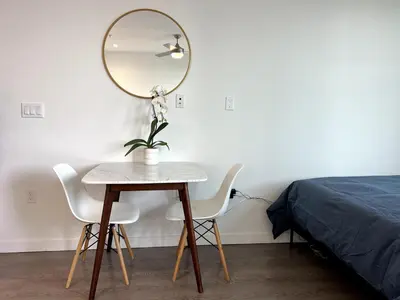 a table with two chairs and a mirror next to a bed at Cozy apartment in Santa Monica parking, Gym, Pool in Los Angeles