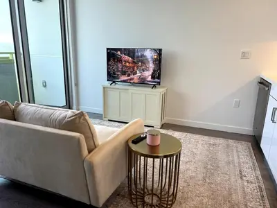 a living room with a couch and a flat screen tv at Cozy apartment in Santa Monica parking, Gym, Pool in Los Angeles