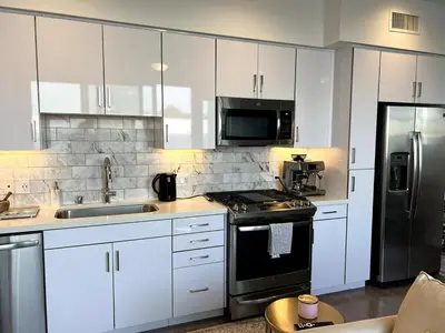 a kitchen with white cabinets and a black stove top oven at Cozy apartment in Santa Monica parking, Gym, Pool in Los Angeles