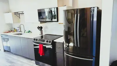 a kitchen with a stainless steel refrigerator and a sink at Melrose Luxe Retreat near The Grove in Los Angeles