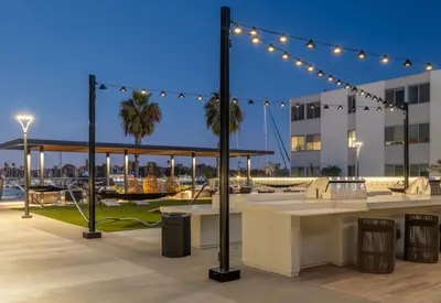 a rooftop patio with lights and a table with chairs at Jade Breeze - Elegant 2BR near Water Outstanding Amenities in Los Angeles