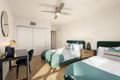 a bedroom with two beds and a desk and a ceiling fan at Jade Breeze - Elegant 2BR near Water Outstanding Amenities in Los Angeles