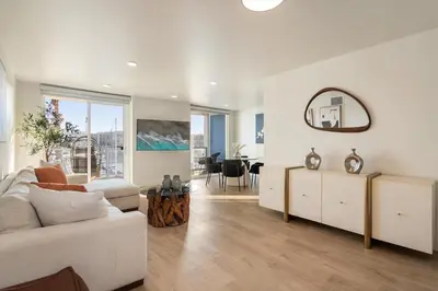 a living room with a white couch and a mirror at Jade Breeze - Elegant 2BR near Water Outstanding Amenities in Los Angeles