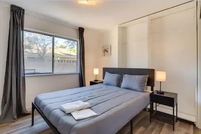 a bedroom with a large bed and a large window at Modern 4-BR near China Lake in Ridgecrest