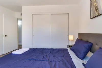 a bedroom with a large bed with blue pillows at Modern 4-BR near China Lake in Ridgecrest