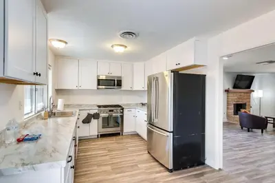 a kitchen with white cabinets and a stainless steel refrigerator at Modern 4-BR near China Lake in Ridgecrest