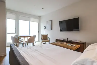 a bedroom with a bed and a table and a television at 2BR Condo in Santa Monica - Walking Distance to Beach, Dining, Shopping & Promenade in Los Angeles