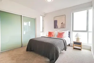 a bedroom with a bed with pink pillows on it at 2BR Condo in Santa Monica - Walking Distance to Beach, Dining, Shopping & Promenade in Los Angeles