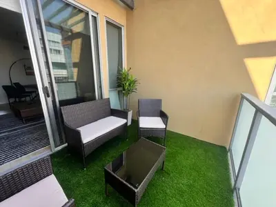 a balcony with two chairs and a couch on the grass at 2BR Condo in Santa Monica - Walking Distance to Beach, Dining, Shopping & Promenade in Los Angeles