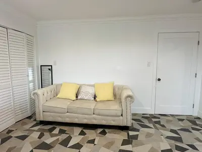 a couch with two yellow pillows in a living room at Luxe Stay Room with Private Bathroom 55 in Los Angeles